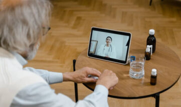 An older man has a medical appointment with his doctor via video in his home